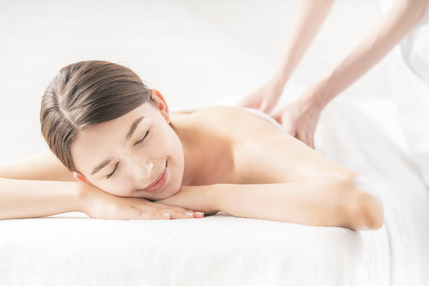 Молода жінка отримує масаж в салоні краси в яскравій атмосфері
 - Фото, зображення