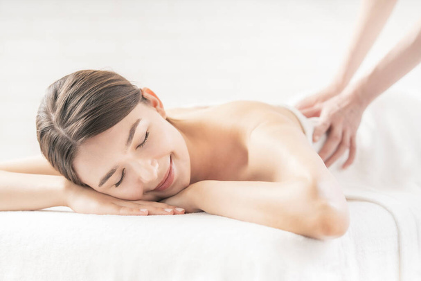 Jovem mulher recebendo uma massagem em um salão de beleza em uma atmosfera brilhante
 - Foto, Imagem
