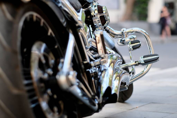 ángulo bajo de neumático trasero negro y engranaje de acero plateado brillante de la motocicleta. Fondo desenfocado
 - Foto, imagen