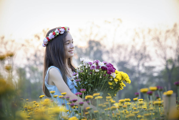 Beautiful girl in vintage dress and hat standing near colorful flowers.Beautiful romantic young woman of flowers posing on a background.Inspiration of spring and summer.Perfume.Art of romantic woman. - Photo, Image