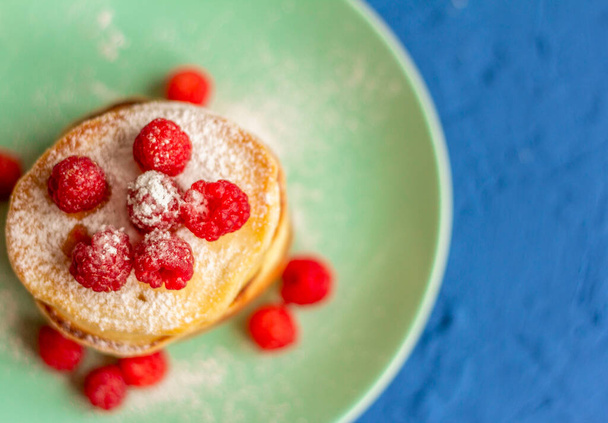 Pancakes with raspberries.A stack of fresh homemade pancakes with berries on a plate.The view from the top. - Photo, Image