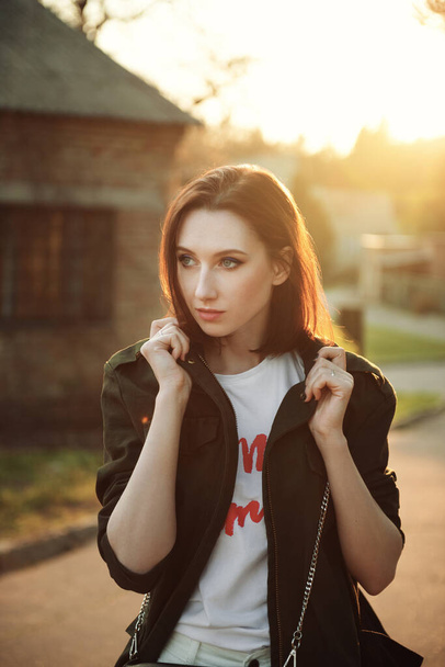 Portrait of young pretty woman in the rays of setting sun. Golden hours. - Photo, Image