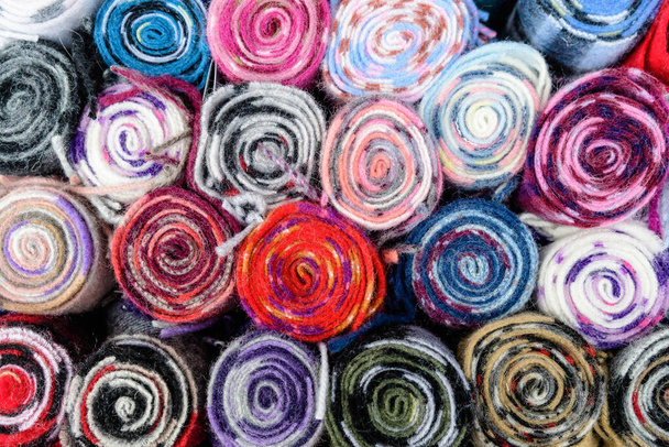 Mixed colored wool scarfs displayed for sale at a traditional store in Edinburgh, United Kingdom, top view or flat lay of a colourful background - Фото, зображення
