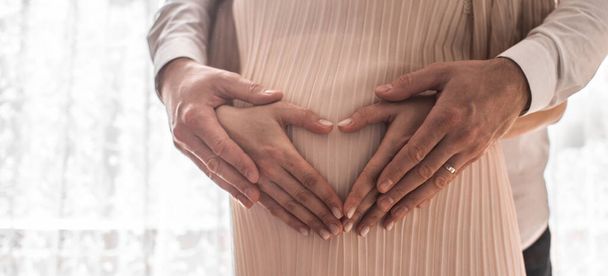 Terhes nők ölelik át a hasukat szív formájában. Családi fogalom. Magas resulotiós kép. - Fotó, kép