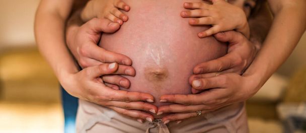 Pais mãos fazendo um coração na barriga da mãe grávida. Mãe e pai com as mãos no bebê
. - Foto, Imagem