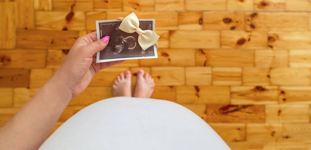 Ultrason resmi olan hamile bir kadın. Seçici odaklanma. insanlar. - Fotoğraf, Görsel