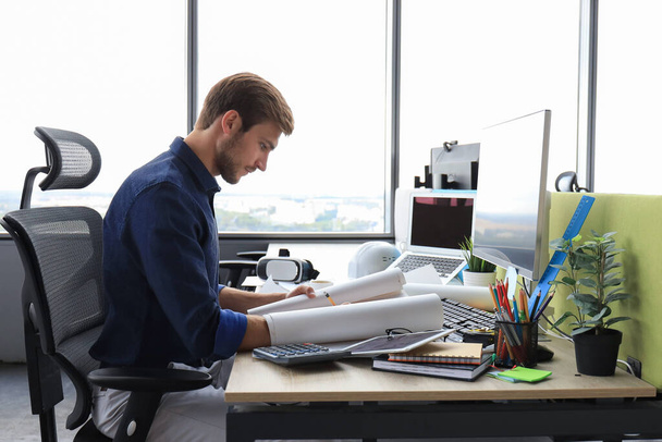Good looking young business man drawing something while working in the office - Photo, Image