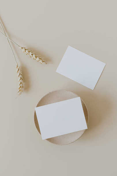 Blank paper cards with mockup copy space and wheat / rye stalks on beige background. Minimal business brand template. Flat lay, top view. - Photo, image