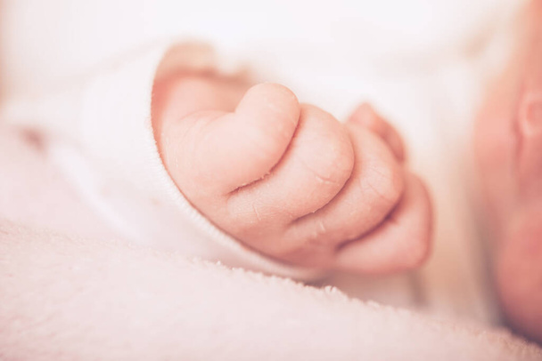 Liebenswertes Baby, das auf dem Bauch schläft. Kleine Hand schlafender Neugeborener aus nächster Nähe. Bild aus nächster Nähe. - Foto, Bild