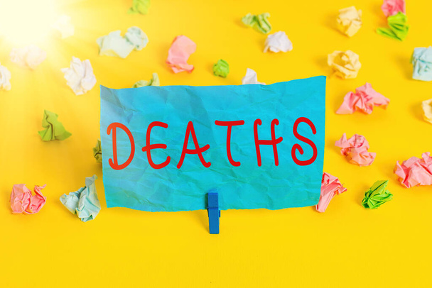 Conceptual hand writing showing Deaths. Business photo showcasing permanent cessation of all vital signs, instance of dying individual Colored crumpled paper empty reminder white floor clothespin. - Photo, Image