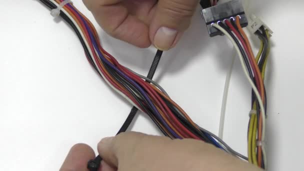 A munkás műanyag nyakkendővel köti meg a vezetékeket.. - Felvétel, videó