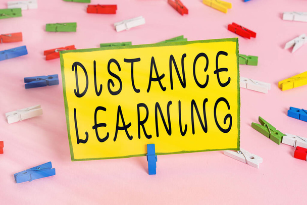 Слова пишуть текст Distance Learning. Бізнес-концепція для освітніх лекцій транслювалася по Інтернету віддалено кольоровими паперами Clothespin порожнє нагадування про рожевий фон заднього офісу. - Фото, зображення