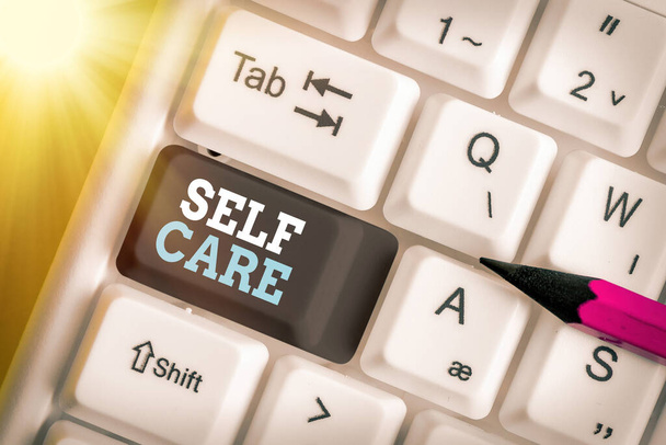 Schreiben Notiz zeigt Self Care. Geschäftsfoto, das die Praxis zeigt, Maßnahmen zur Erhaltung oder Verbesserung der eigenen Gesundheit zu ergreifen Farbige Tastatur-Taste mit Zubehör auf leerem Kopierraum angeordnet. - Foto, Bild