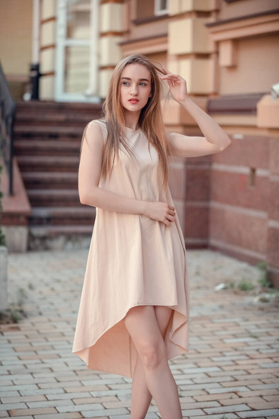 portrait of young woman posing on the street. Femail model wearing light dress walking outdoor - Photo, Image