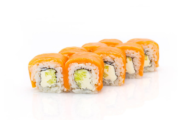 Japonský sushi rohlík s lososem, okurkou, filadelfským smetanovým sýrem a lososem navrchu. izolované na bílém pozadí. Izolace menu. Asijská mísa s odrazem - Fotografie, Obrázek