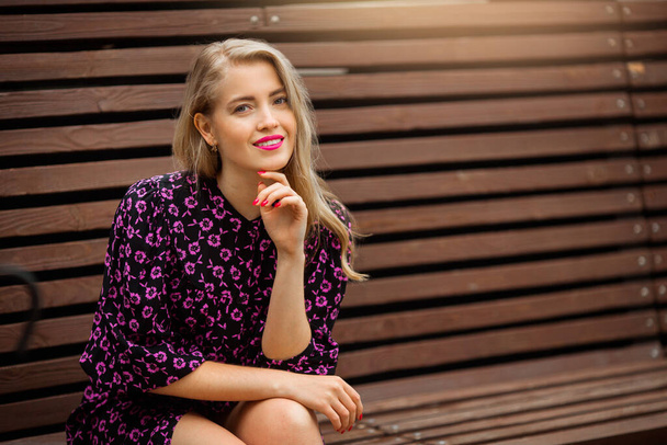 beautiful young woman with makeup in summer dress on the bench - Foto, Imagen