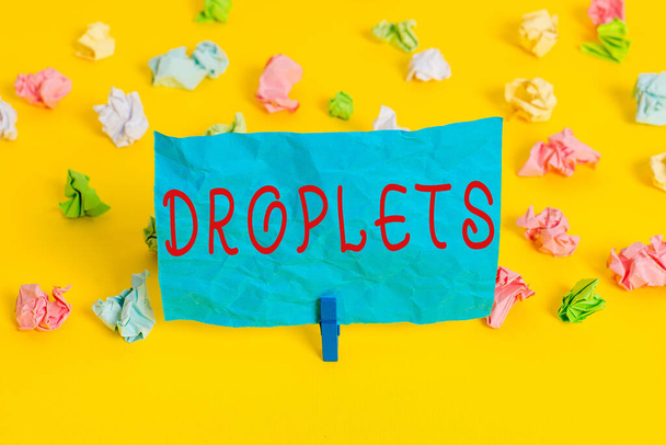 Conceptual hand writing showing Droplets. Business photo showcasing very small drop of a liquid can be found in certain wet places Colored crumpled paper empty reminder white floor clothespin. - Photo, Image