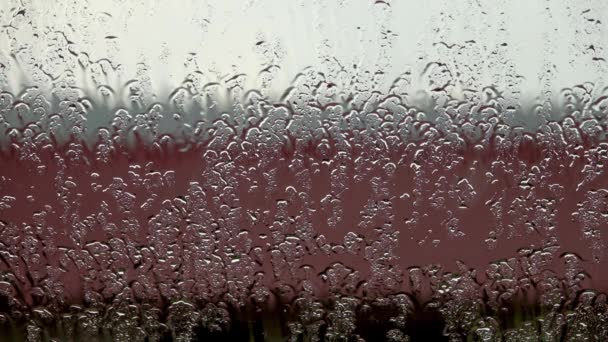 gocce di pioggia su finestra chiara con nuvole scure sullo sfondo - Filmati, video