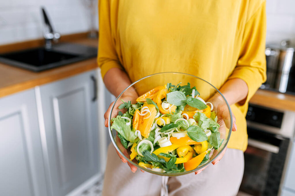 A bowl of veggie salad in female hands - Фото, зображення