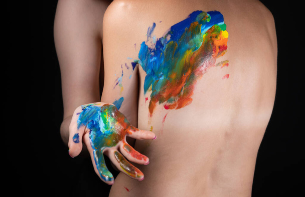 Image of woman messing up rainbow on nude back - Photo, image