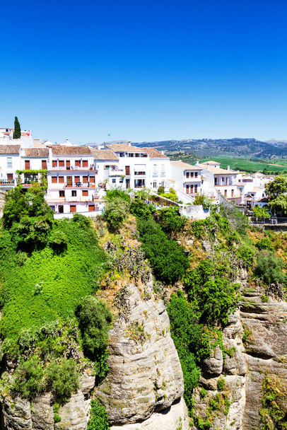 Talot roikkuu kallioita Ronda Andalucian kaupunki Etelä-Espanjassa aurinkoisena päivänä. Ronda on suosittu matkailukohde valkoisen kaupungin reitillä ja usein vieraili monet turistit - Valokuva, kuva