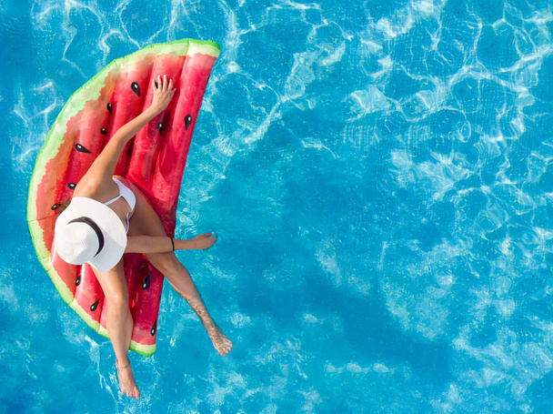 Zomer mode concept - bruinende vrouw met zonnehoed en watermeloen - Foto, afbeelding