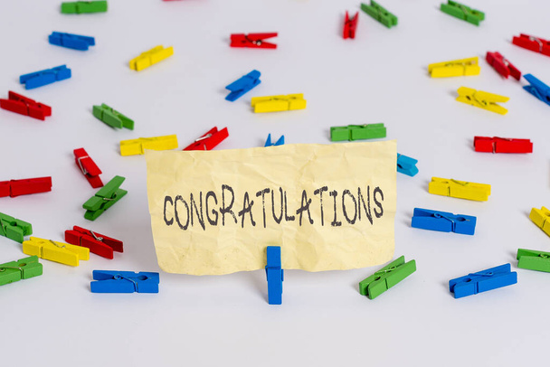 Handwriting text writing Congratulations. Concept meaning a special occasion that expressing gratitude or good wishes Colored clothespin papers empty reminder white floor background office. - Photo, Image