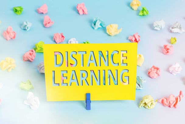 Text sign showing Distance Learning. Conceptual photo educational lectures broadcasted over the Internet remotely Colored crumpled papers empty reminder blue floor background clothespin. - Photo, Image