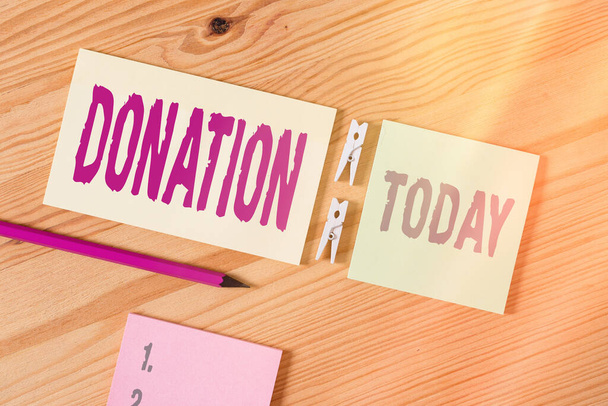 Conceptual hand writing showing Donation. Business photo text something that is given to a charity, especially a sum of money Colored crumpled papers wooden floor background clothespin. - Photo, Image