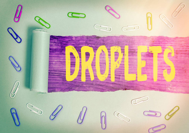 Handwriting text Droplets. Concept meaning very small drop of a liquid can be found in certain wet places Rolled ripped torn cardboard placed above a wooden classic table backdrop. - Photo, Image
