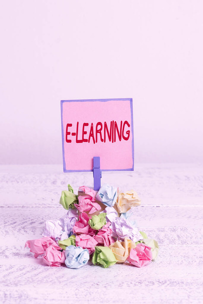 Text sign showing E learning. Conceptual photo training through electronic media usually over the internet Reminder pile colored crumpled paper clothespin reminder white wooden space. - Foto, Bild