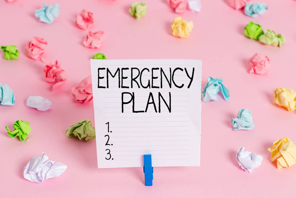 Conceptual hand writing showing Emergency Plan. Business photo showcasing instructions that outlines what workers should do in danger Colored crumpled papers empty reminder pink floor clothespin. - Photo, Image