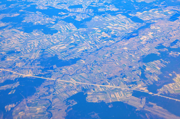 Vue aérienne du méandre et des plaines de la rivière. Vue panoramique sur la rivière et l'autoroute. Vue de la fenêtre de l'avion. Survoler la Pologne  - Photo, image