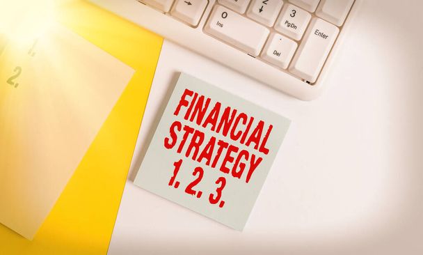 Handschriftlicher Text Finanzstrategie 1 2. 3. Konzept Bedeutung auf Einsichten aus einem Geschäftskontext aufbauen Leeres leeres Papier mit Kopierraum und PC-Tastatur über orangefarbenem Hintergrundtisch. - Foto, Bild
