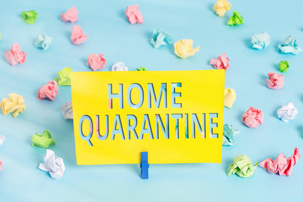 Text sign showing Home Quarantine. Conceptual photo Encountered a possible exposure from the public for observation Colored crumpled papers empty reminder blue floor background clothespin. - Photo, Image