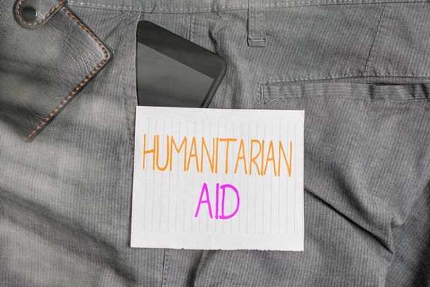 Conceptual hand writing showing Humanitarian Aid. Business photo text immediate assistance provided after natural and manmade disaster Smartphone device inside trousers front pocket with wallet. - Photo, Image