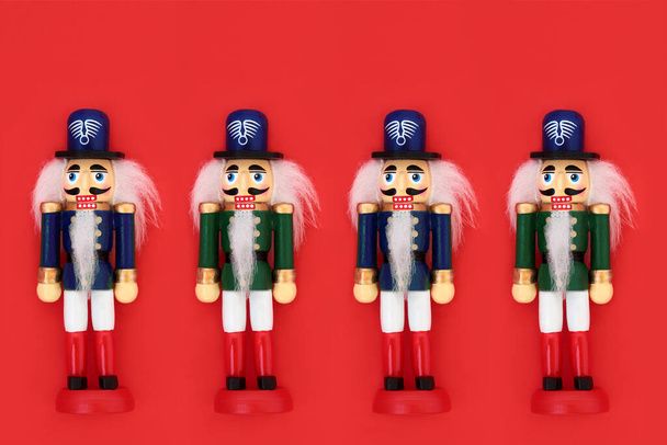 Nussknacker Spielzeugsoldaten in einer Reihe auf rotem Hintergrund. Traditionelles Symbol für Weihnachten & Feiertage. - Foto, Bild