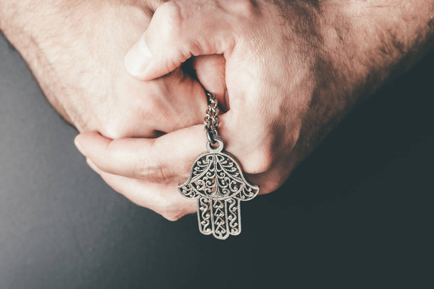 detailní záběr složených rukou držících amulet Hamsa známý také jako Ruka Fatimy - Fotografie, Obrázek