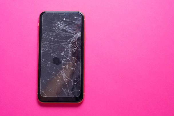 Розбите скло екран мобільного телефону на рожевому фоні
. - Фото, зображення