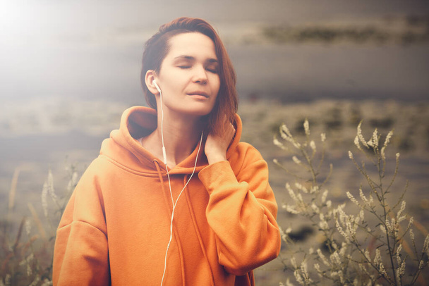 Beautiful Young Woman with Earphones Outdoors Enjoy Music. Hipster Girl Traveling - Φωτογραφία, εικόνα