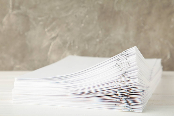 Stack of white paper with clips on grey background. Top view - Fotografie, Obrázek