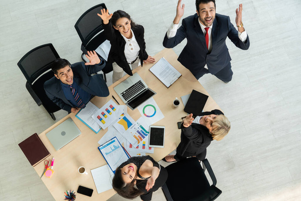 Successful business people celebrate together with joy at office table shot from top view . Young businessman and businesswoman workers express cheerful victory showing success by teamwork . - Foto, afbeelding