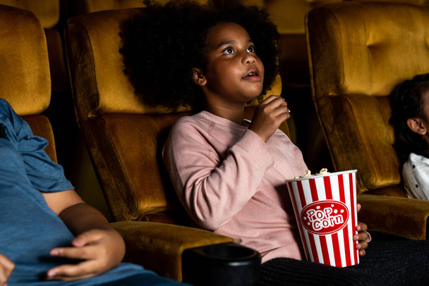 Drie kinderen hebben plezier en genieten van film kijken in de bioscoop - Foto, afbeelding