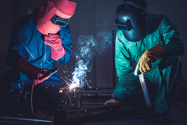 Metal welding steel works using electric arc welding machine to weld steel at factory. Metalwork manufacturing and construction maintenance service by manual skill labor concept. - Photo, Image