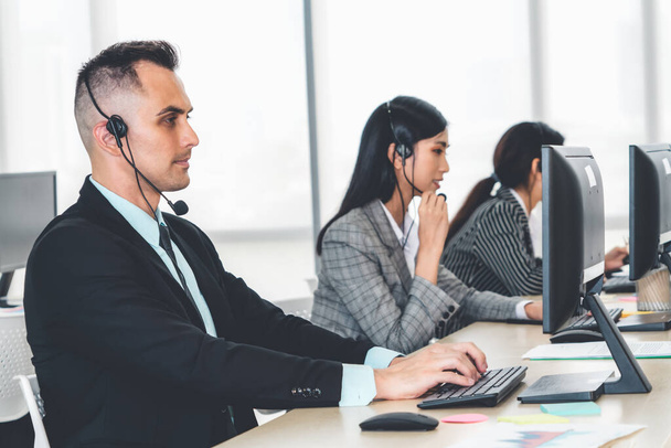Business people wearing headset working in office to support remote customer or colleague. Call center, telemarketing, customer support agent provide service on telephone video conference call. - Zdjęcie, obraz