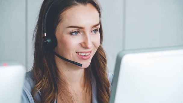 Business people wearing headset working in office to support remote customer or colleague. Call center, telemarketing, customer support agent provide service on telephone video conference call. - Фото, изображение