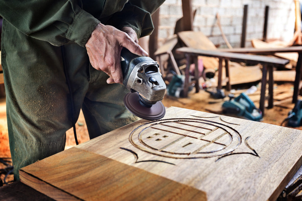 Travailleur sculptant du bois
 - Photo, image