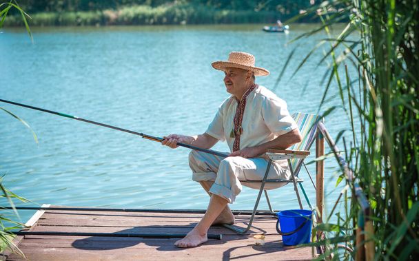 Balık tutan kıdemli bir adam, emekli olmuş insanların yaşam tarzı. Yaşlıların hobisi - Fotoğraf, Görsel