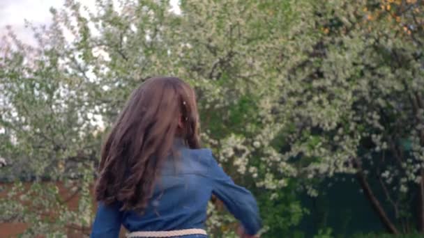 Little cute girl in blue denim sundress catches soap bubbles in the Park. - Imágenes, Vídeo