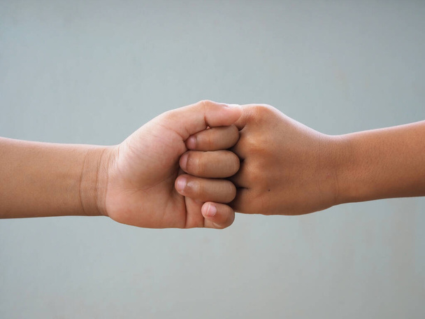 Boy fist bumping On a gray background.new normal concept. - Foto, immagini
